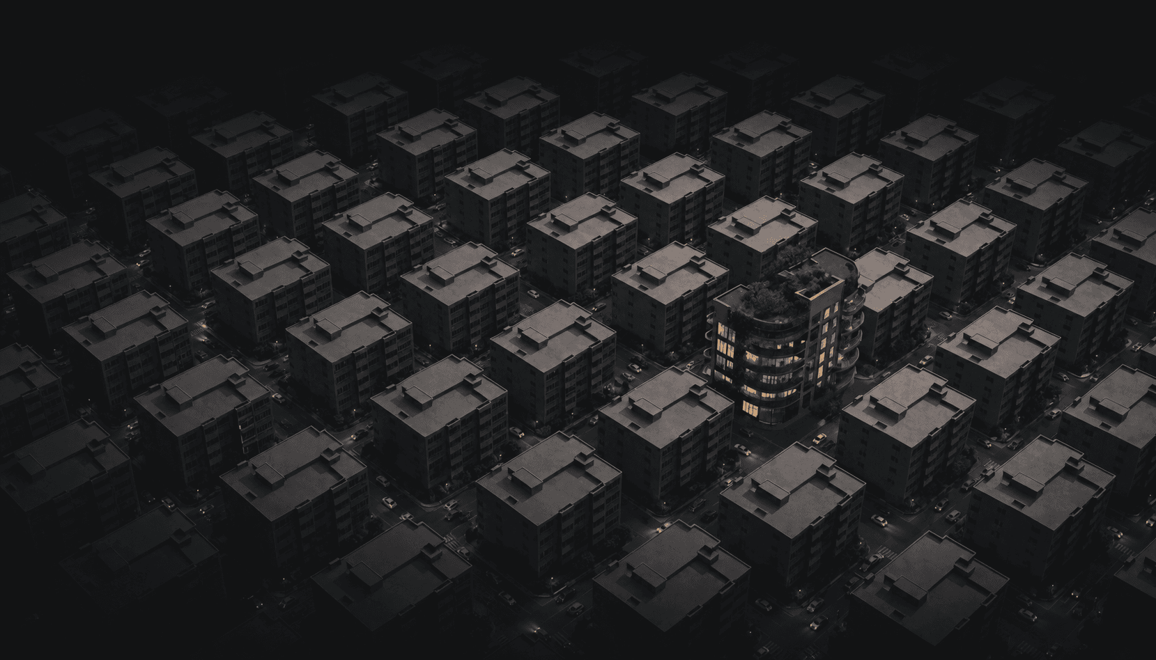 An aerial view of a uniform grid of identical grey apartment buildings, with one strikingly beautiful, angular black and white modern building standing out among the crowd